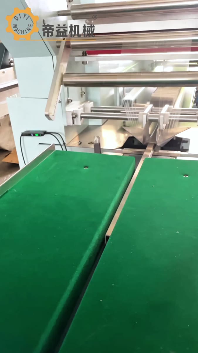 图 1: 枕式包装机进料现场,取自原视频12秒。位置标注:画面下方为来料输送段,上方为进入包装机构的方向;先沿材料中心线检查偏移。原片未提供封合界面温度。